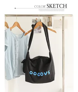 Black canvas crossbody bag with blue letter print and knotted shoulder strap detail