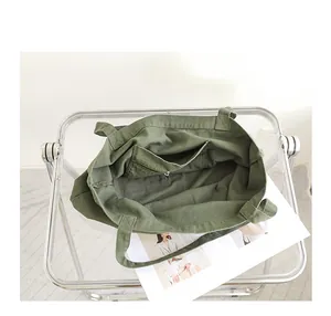 Vista interior de un bolso tote de lona verde oliva con un práctico bolsillo con cremallera