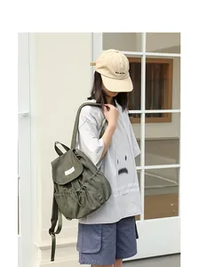 Mochila vintage de lona verde oliva con cierre de cordón y detalles de diseño plisados