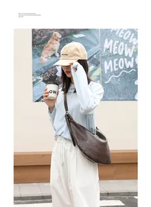 Detalle de una modelo asiática con un bolso bandolera retro de cuero PU marrón estilo dumpling