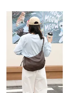 Bolso bandolera de cuero PU suave marrón usado por una modelo en la calle