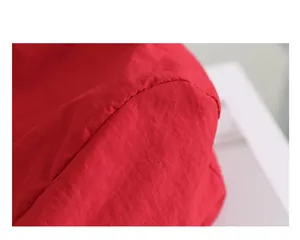 Primer plano de un bolso tote de nailon rojo con textura de tela y costuras finas