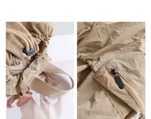 Close-up detail of beige ripstop nylon backpack drawstring closure and zipper pocket.