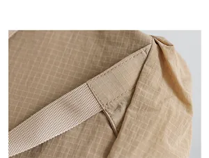 Close-up of the durable nylon grid fabric and neat stitching on a khaki backpack detail shot.