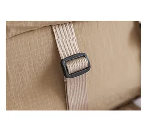 Detail of durable beige grid nylon backpack strap with a black plastic buckle adjustment