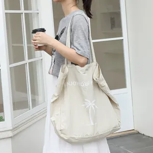 Lässige minimalistische beige Nylon-Einkaufstasche mit weißem Palmendruck und Schriftzug