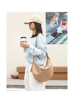 Elegante bolso de hombro estilo japonés de cuero PU suave llevado por una modelo al aire libre.