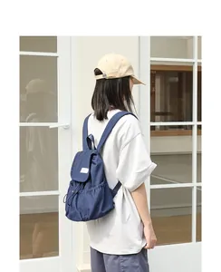 Vista detallada de una mochila de lona azul informal con cordón y solapa