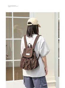 Mochila de lona marrón casual con cordón y diseño plisado en la espalda de la modelo