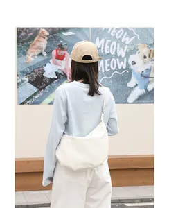 Modelo con un bolso bandolera de piel sintética crema minimalista en forma de media luna