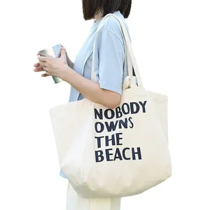Bolso tote de lona crema minimalista con estampado artístico del eslogan Nobody Owns The Beach