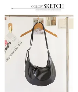 Vista detallada de un bolso hobo de cuero PU negro vintage colgado en una percha.