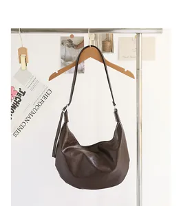 Bolso de hombro vintage de piel sintética suave marrón chocolate en una percha