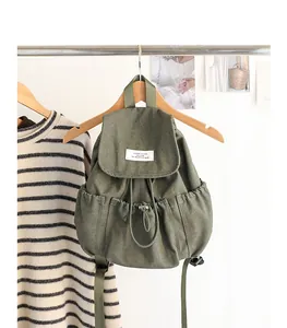 Vista detallada de una mochila de lona verde oliva con cordón de estilo vintage