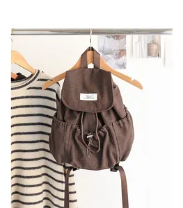 Vista frontal detallada de una mochila de lona marrón con cordón y solapa de diseño