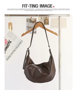 Bolso hobo grande de piel sintética marrón suave colgado en una percha de madera