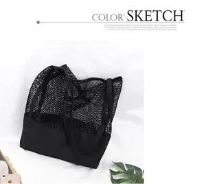 Detalle de bolso tote de malla negra con base de lona y diseño calado para compras