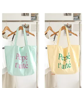 Detailed look at stylish nylon tote bags with chic letter prints in mint green and soft yellow