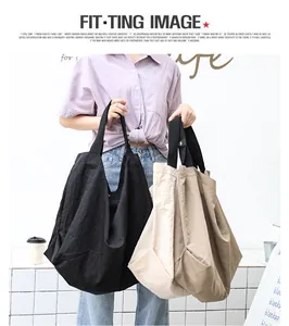 Modella con grandi borse tote in nylon nero e beige in un ambiente dallo stile minimal.