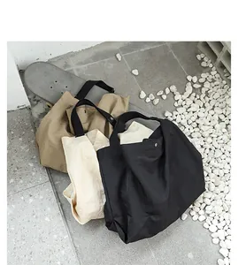 Tre grandi borse tote in nylon impermeabile nei colori kaki, beige e nero casual