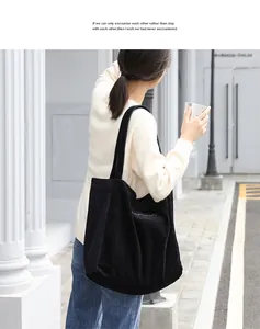 Primer plano de un bolso de pana negro informal con bordado en un estilo de calle real