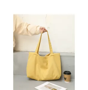 Close-up of stylish yellow solid color canvas tote bag in a minimalist lifestyle setting