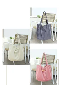 Vista detallada de bolsos de hombro de pana en beige, gris y rosa colgados en sillas blancas