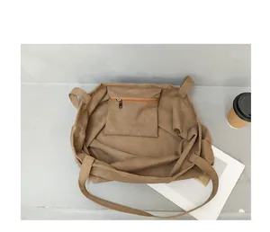 Detailed interior view of brown canvas tote bag showing the small zippered inner pocket