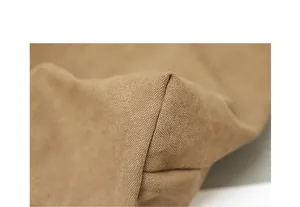 Detailed macro view of high-quality brown canvas fabric and corner stitching on a tote bag