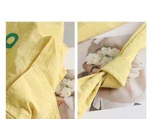 Close-up detail of a yellow nylon crossbody bag with visible stitching and knot strap