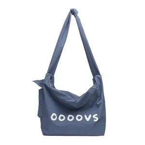Stylish blue nylon messenger bag featuring white ooovs letter print and knotted strap