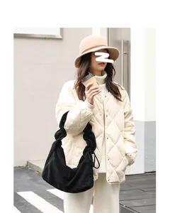 Detail view of a stylish black corduroy shoulder bag paired with a retro Japanese outfit
