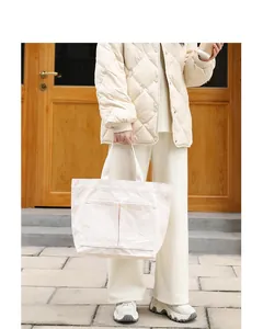 Minimalistische cremefarbene Segeltuchtasche mit Außentaschen in einer Outdoor-Szene