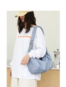 Bolso bandolera de piel PU azul claro estilo dumpling llevado por una modelo para diario