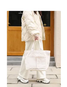 Detail einer großen Canvas-Einkaufstasche mit zwei Vordertaschen in Off-White