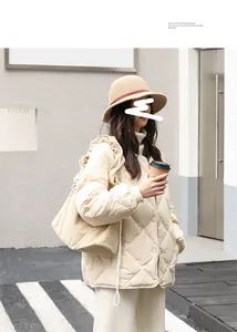 Woman in quilted jacket carrying a beige corduroy drawstring shoulder bag outdoors