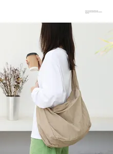 Detailed side view of khaki nylon shoulder bag worn by model