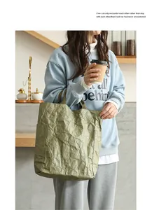 Lifestyle view of an eco-friendly green DuPont paper tote bag with crumpled texture