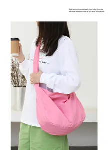 Detailed lifestyle shot of a minimalist pink nylon crossbody bag worn by a model