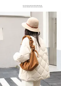 Brown corduroy shoulder bag with pleated drawstring strap worn with a white jacket