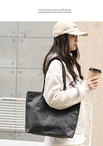 Model carrying a black wrinkled Dupont paper tote bag in a casual outdoor setting