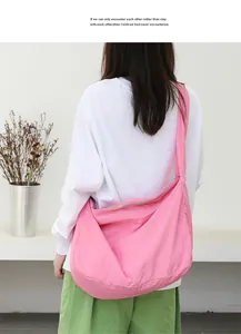 Back view of a model wearing a pink nylon shoulder bag in a casual minimalist style.
