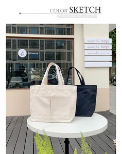 Nebeneinanderliegende weiße und schwarze Canvas-Taschen in einem modernen Außenbereich