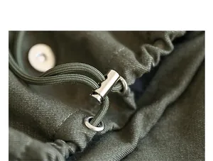 Primer plano detallado de mochila de lona verde oliva con cordón y cierre de metal