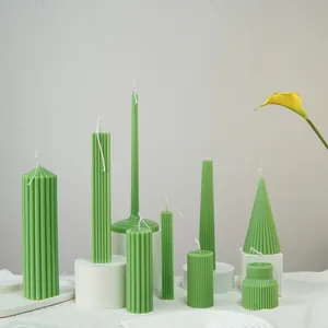 Macro view of green geometric fluted candles featuring various pillar and cone shapes