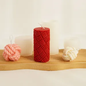 Detailed view of knitted texture candle molds with finished wax balls on wood tray.