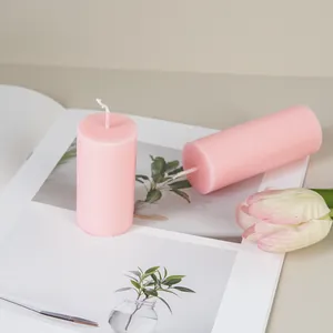 Close-up of smooth pink cylindrical pillar candles on a lifestyle background