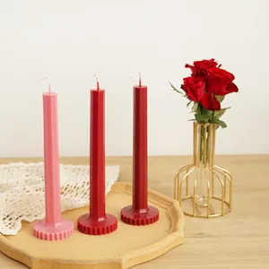 Close-up of three colorful geometric octagonal pillar candles with gear-textured bases