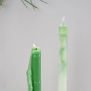 Detailed view of two green bamboo-shaped scented candles featuring realistic dripping wax.