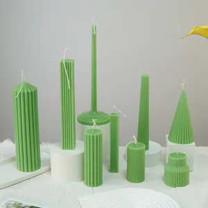 Collection of sage green ribbed pillar candles in various geometric shapes